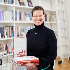 Ayelet Shachar in office with book titled "The Shifting Boarder" on table in foreground