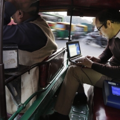 Joshua Apte in back of vehicle looking at laptop